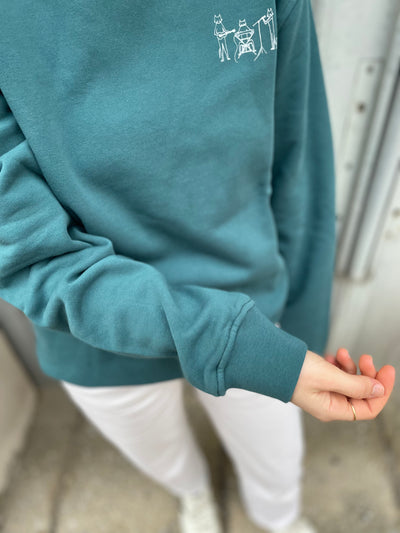 Close up von Frau in nachhaltigem Sweatshirt in Grün mit CatBand-Motiv aus Wien von vorne