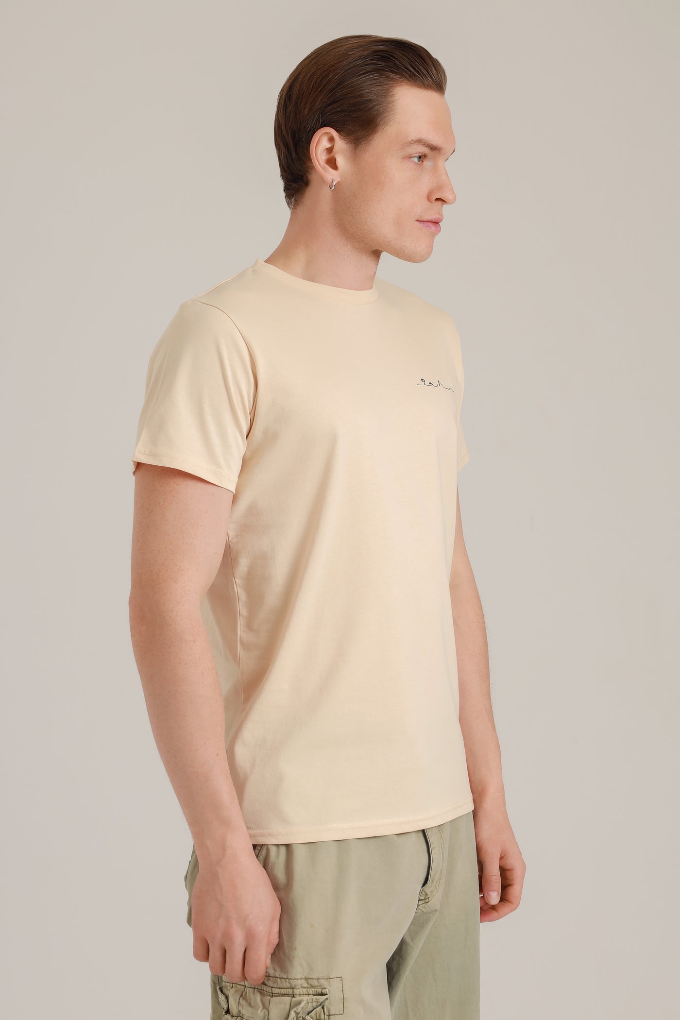 Mann mit nachhaltigem Shirt in Beige mit Insel-Motiv aus Wien seitlich