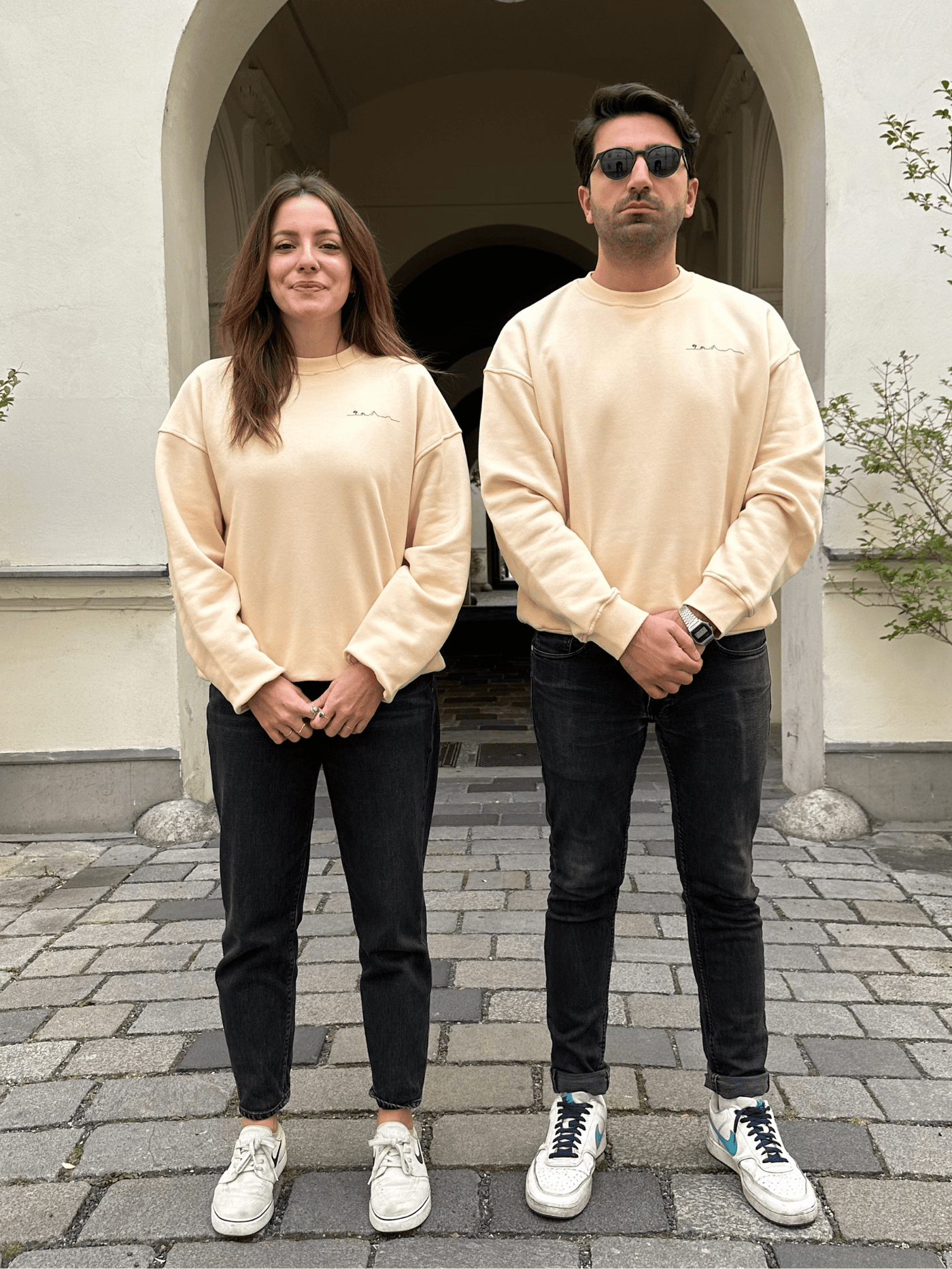 Menschen in fairem Sweateshirt in Gelb mit Insel-Motiv aus Wien